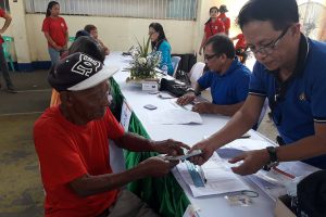 A senior citizen receives P3,500-cash from PRC