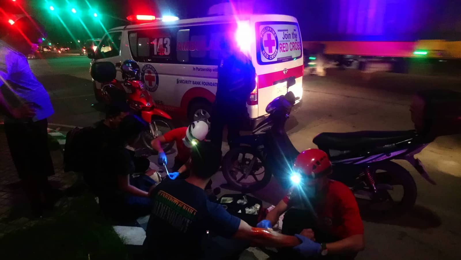 motorcycle rider treated for his wounds by Red Cross EMS Team