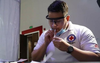 Philippine Red Cross personnel taking the Saliva RT-PCR Test